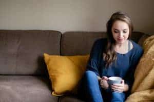 Woman wearing a blue bralette underneath a blue long sleeve top and blue jeans