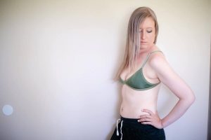 Woman checking if her green bra is curling up