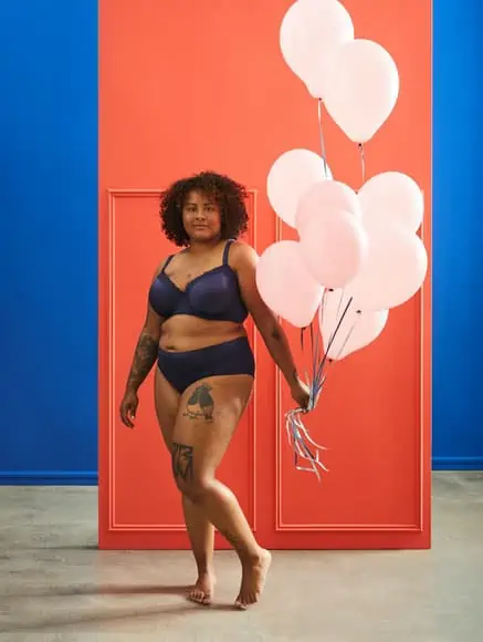 Woman holding balloons while wearing a blue lingerie