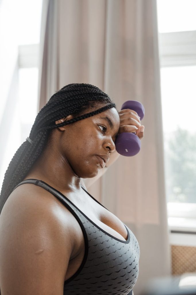 Woman holding weights while wearing a gray sports bra