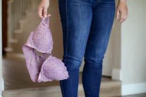 A person holding a purple laced bra