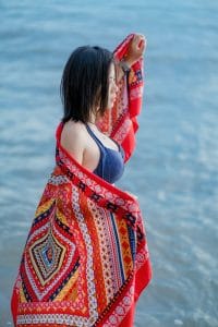 A woman in a blue bra holding a red scarf
