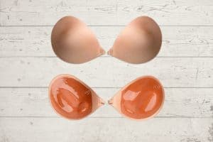The front and back view of a brown sticky bra placed on a wooden background