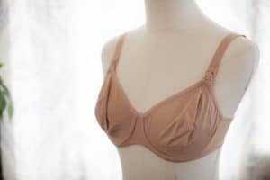 Brown underwired nursing bra with front clips placed on a mannequin