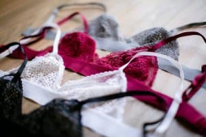 Different colors of knitted wireless bralettes placed on a brown wooden floor