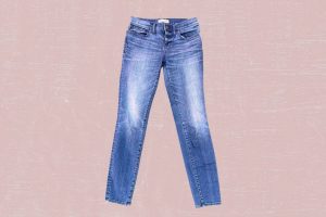 Faded blue denim jeans placed on a pink background