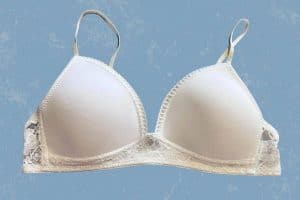 White non-wired bra with lace design and thin straps placed on a blue background