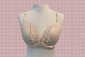 A white full-coverage bra with a lace design placed on a white mannequin