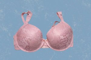 A pink full-coverage underwire bra with lace and adjustable straps placed on a blue background