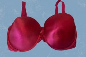 A red full-coverage underwire bra with adjustable straps placed on a blue background