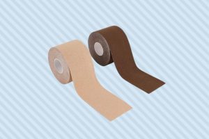 Two rolls of boob tapes with brown and cream colors were placed on a blue-striped surface