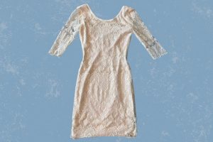 A white lace half-sleeve bodycon dress placed on a blue background