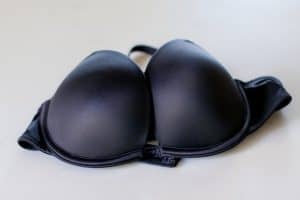 A black push-up bra with an underwire placed on a white surface