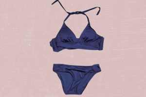 Navy blue two-piece swimsuit placed on a pink background