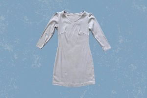 A white half-sleeve v-neck bodycon dress placed on a blue background