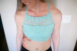 A top view of a woman wearing a blue high-neck bralette with a floral lace design