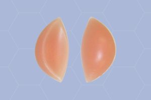 A pair of brown chicken cutlets bra on a blue background