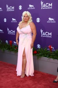 Beth Chapman wearing a long pink gown with a high slit at the 2013 Academy of Country Music Awards