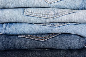 Folded blue jeans piled on top of one another