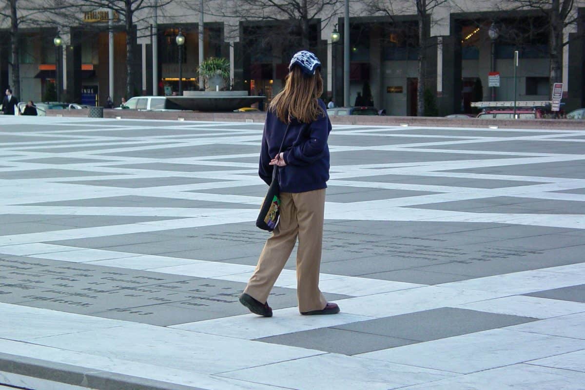 A woman standing in the middle of the plaza wearing khaki pants
