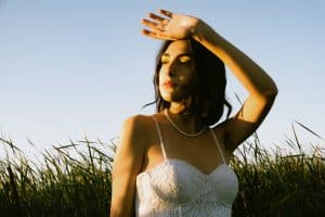 A woman wearing a white bustier while posing