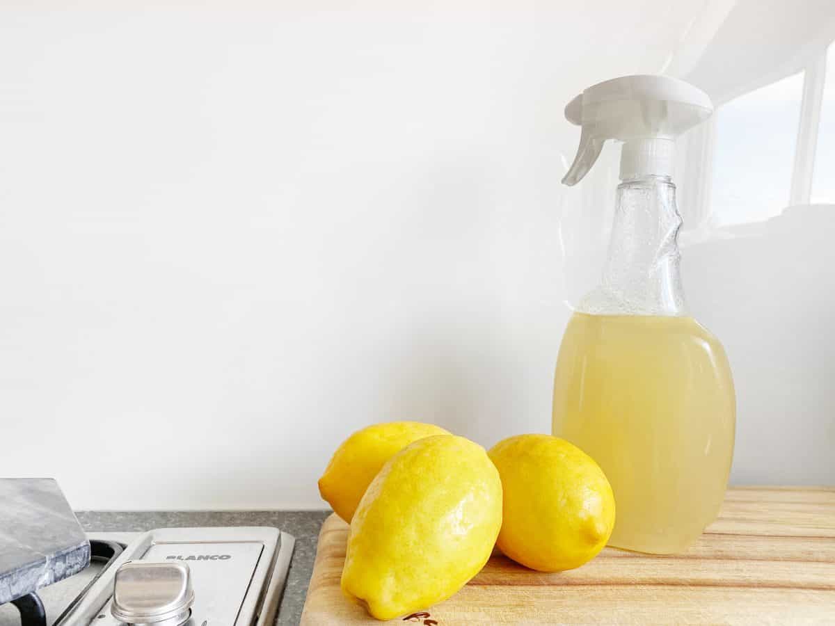 Three pieces of lemon and a spray bottle with lemon juice