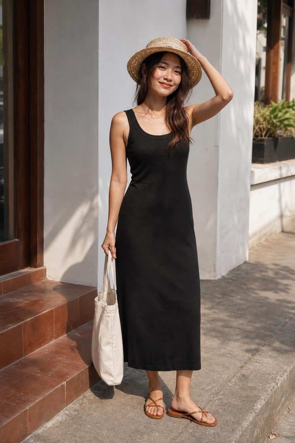 Black cotton tank dress, flat leather sandals, straw hat, canvas tote, warm city sidewalk (option 1)