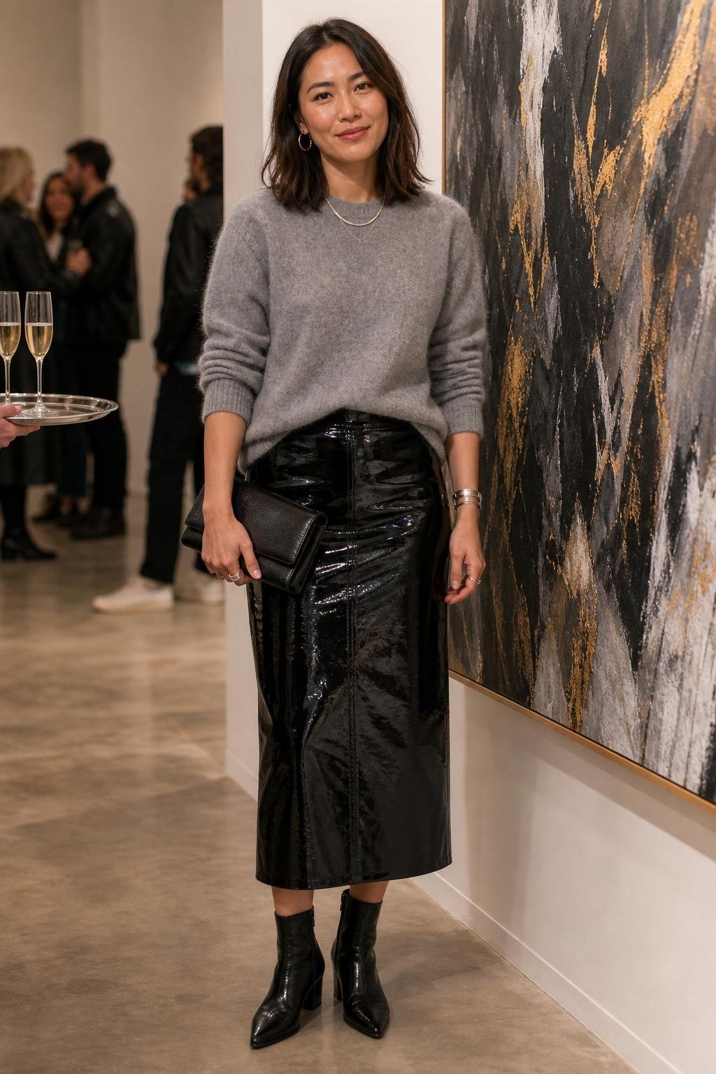 Black patent leather midi skirt, soft gray sweater, ankle boots, silver and gold jewelry, gallery opening (option 1)