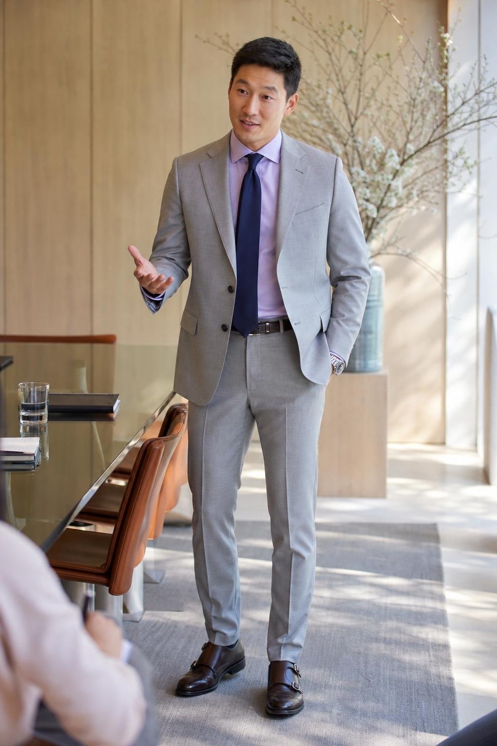 Light gray suit, lavender dress shirt, navy tie, dark brown monk-strap shoes, spring client meeting room (option 2)