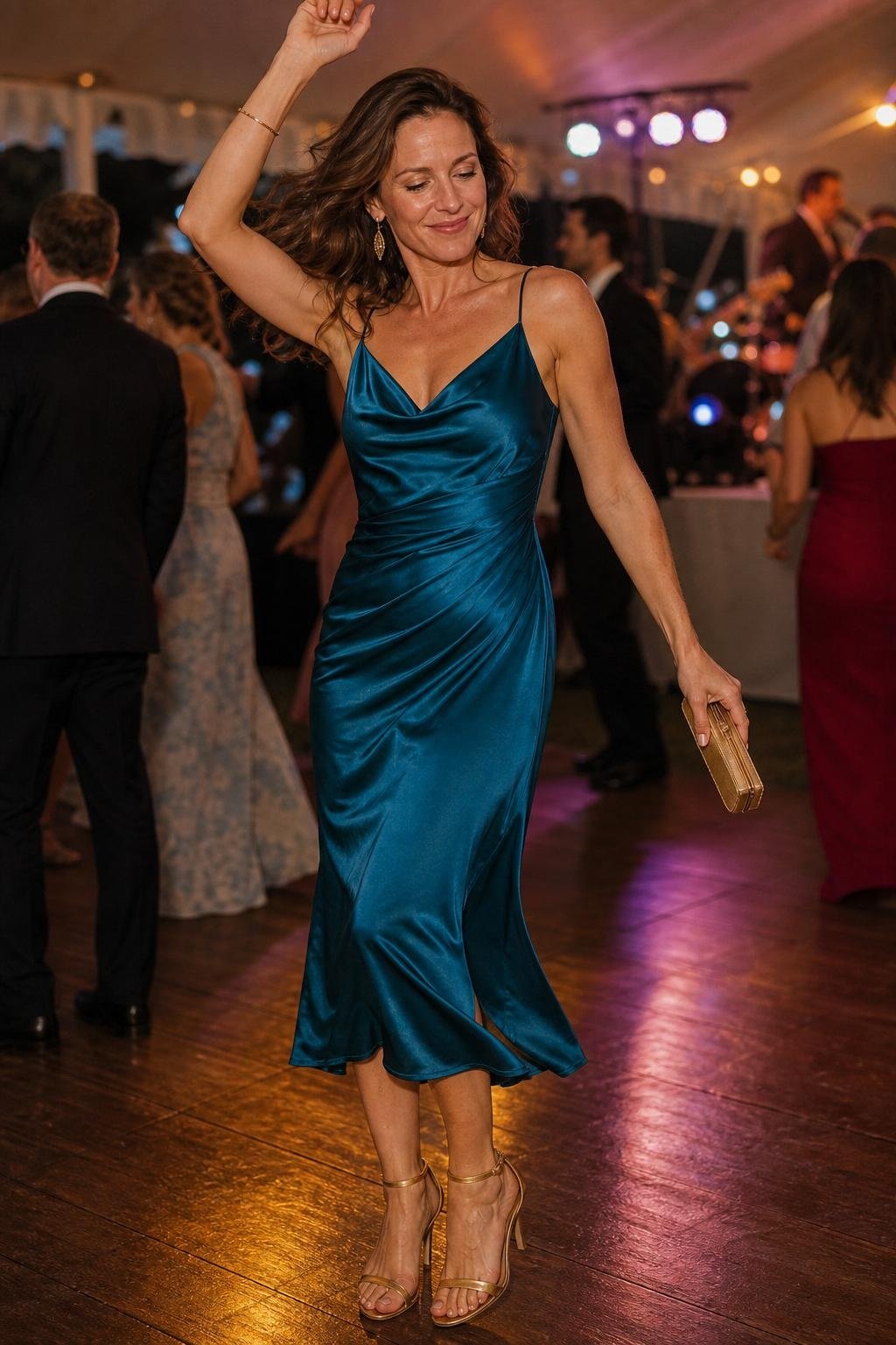 Peacock blue draped midi dress with gold clutch on a lively reception dance floor (option 2)
