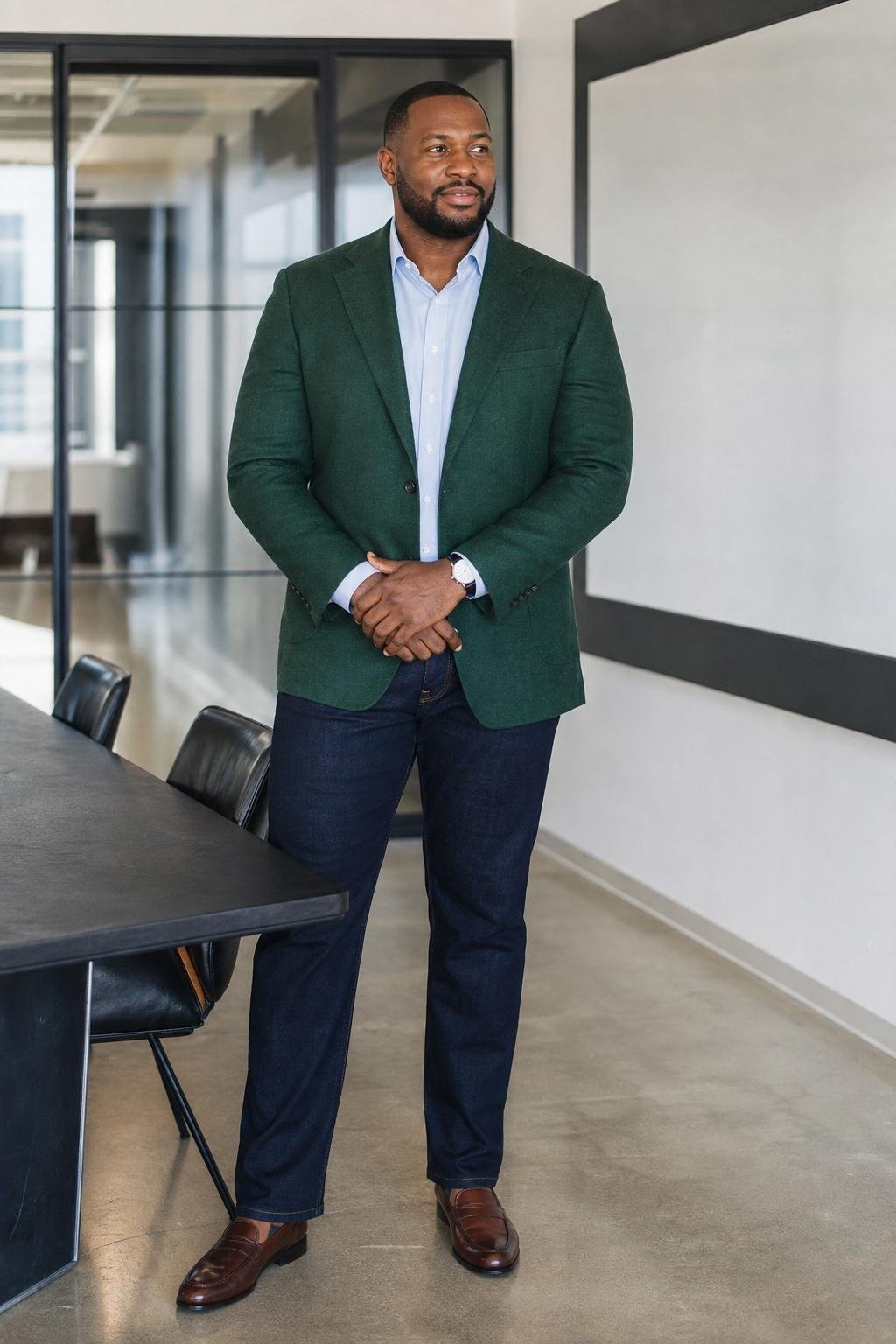 Pine green tailored jacket, dark denim, pale blue shirt, merlot loafers in a startup boardroom (option 1)