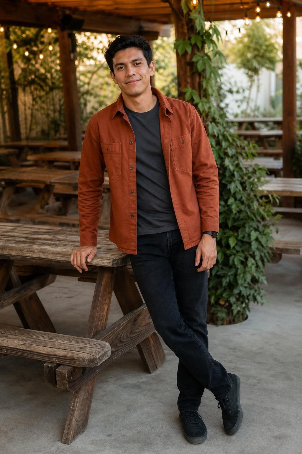 Rust cotton overshirt, black jeans, charcoal tee, clean canvas sneakers, casual brewery patio scene (option 1)