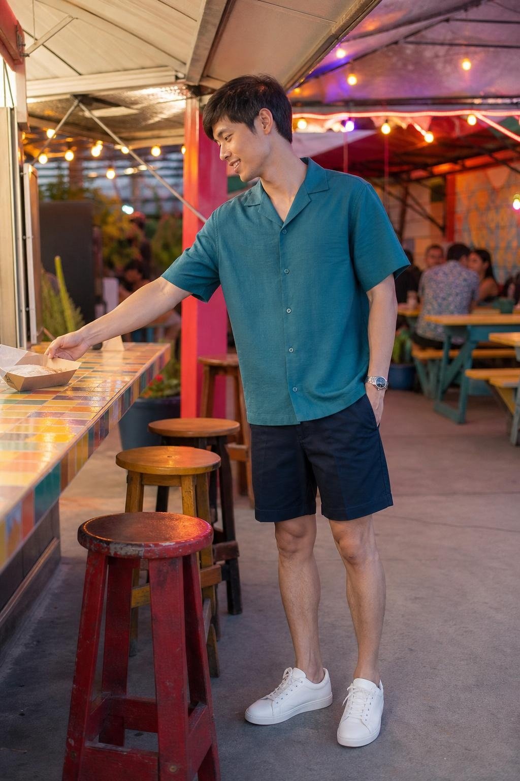 Teal camp collar shirt, navy tailored shorts, white leather sneakers, relaxed outdoor taco stand dinner (option 1)
