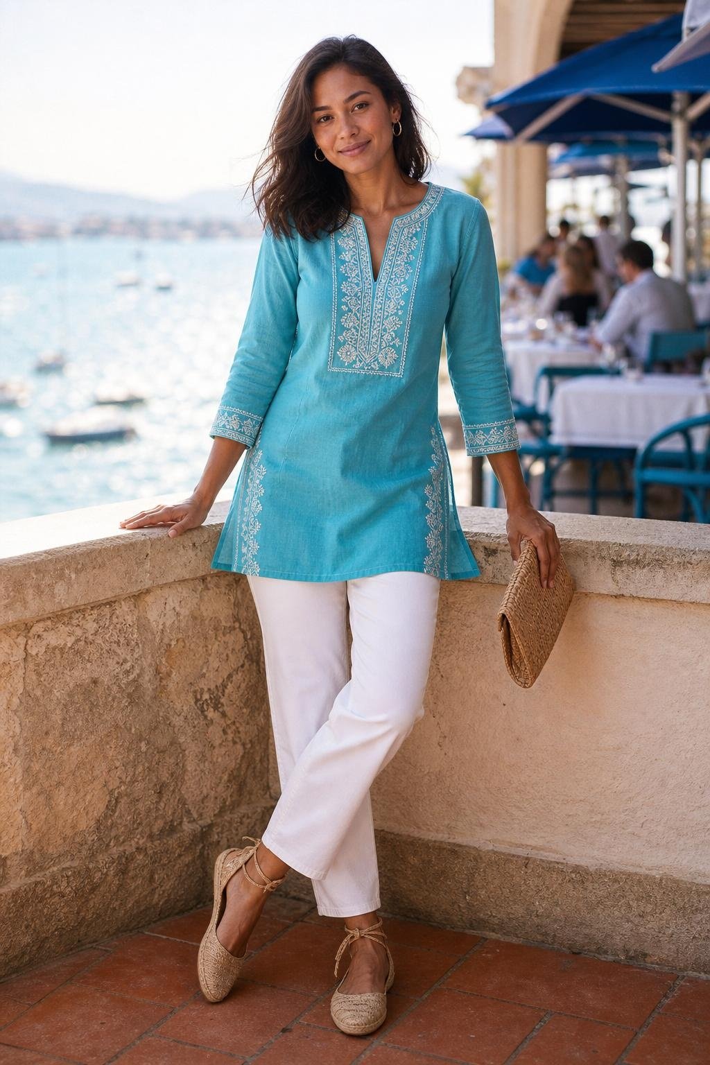 Turquoise embroidered tunic, white straight jeans, tan espadrilles, seaside lunch terrace (option 2)