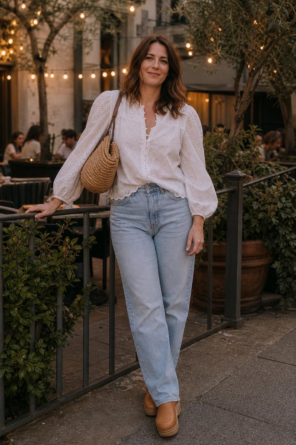 White eyelet blouse, light straight-leg jeans, tan clogs, woven shoulder bag, casual patio dinner scene (option 2)