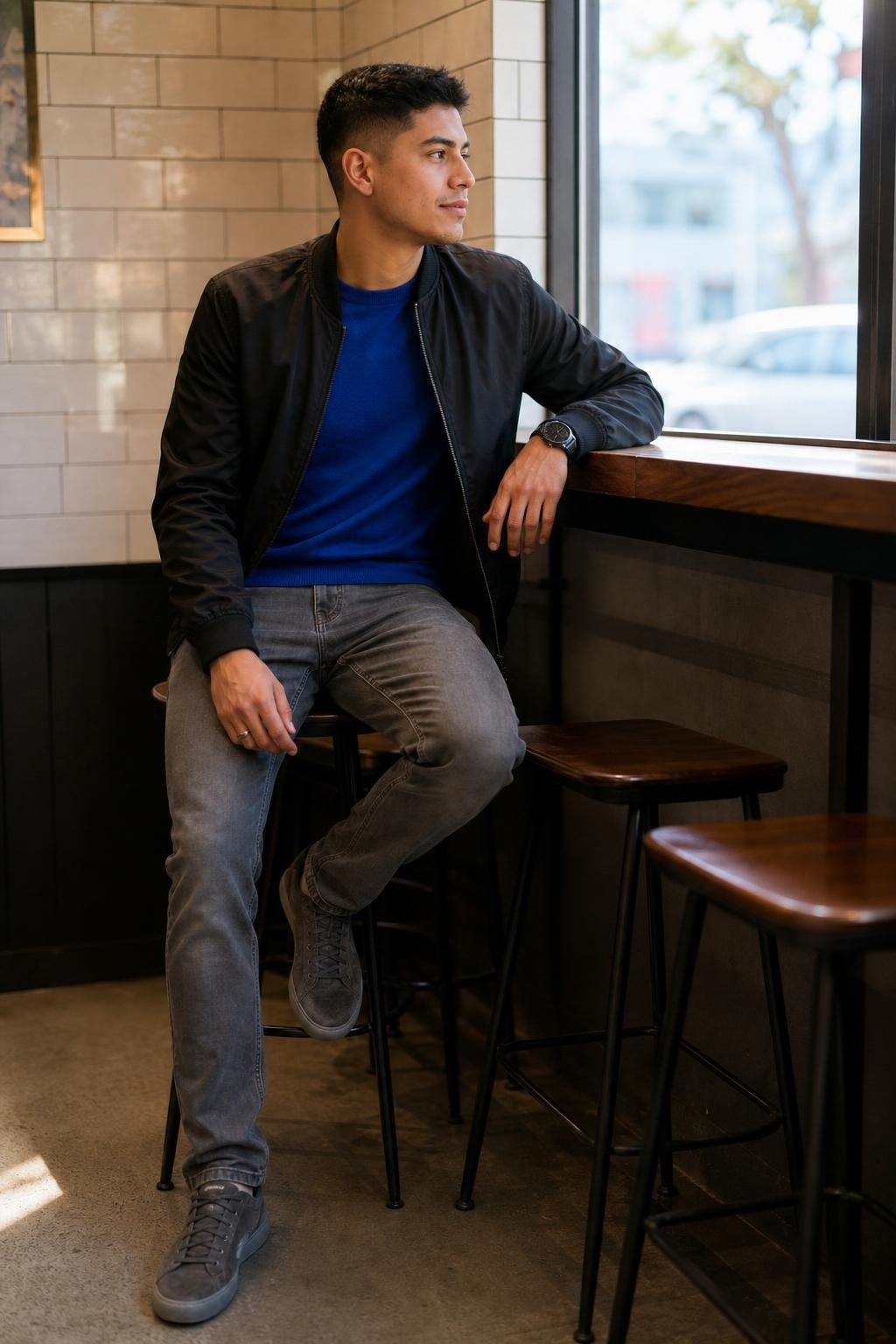 Cobalt blue crewneck sweater, gray slim-straight jeans, black bomber jacket, gray suede sneakers, casual city lunch (option 2)