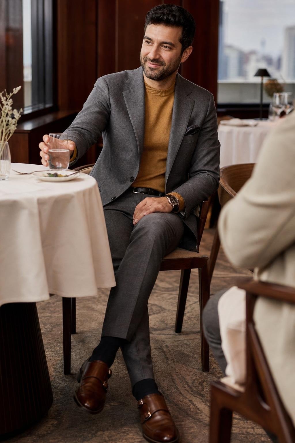 Medium gray suit, mustard fine-gauge sweater, brown leather monk strap shoes, business lunch table setting (option 2)
